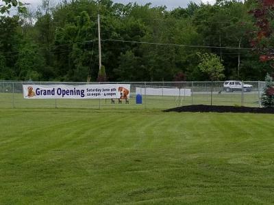 fence with grand opening sign